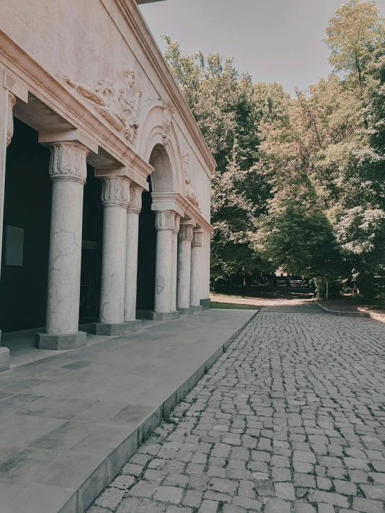 a pathway made of bricks between two columns