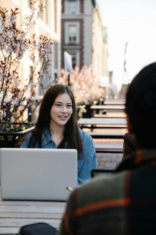 two women sitting at a table with their laptops open