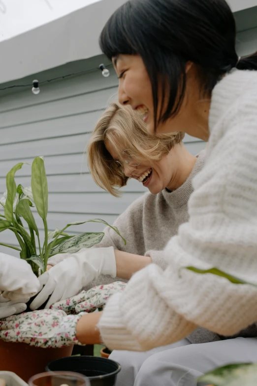 the woman in the sweater is holding soing and wearing gloves