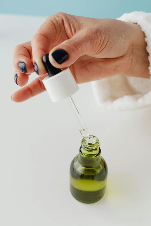 a female hand holding a small air freshener bottle