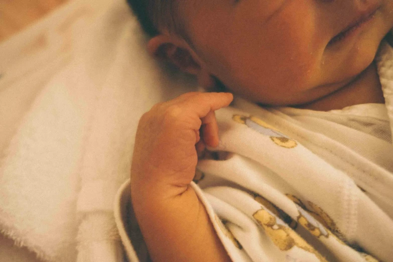 a young baby holding onto his mother's arm