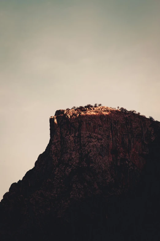 there are two birds flying on the top of this mountain