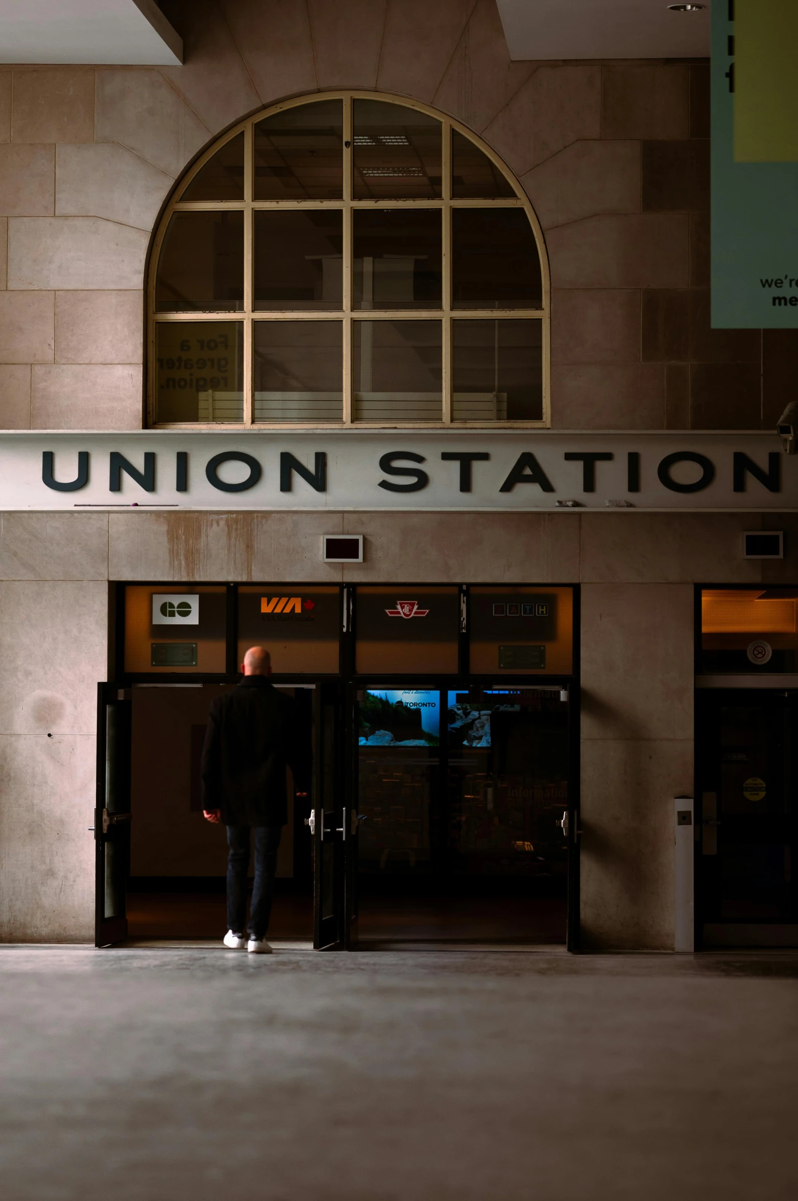 a man standing outside of a building with the door open