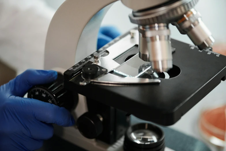 two gloves on the arm of a person working with a microscope