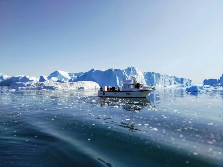 a boat floating in the ocean next to icebergs