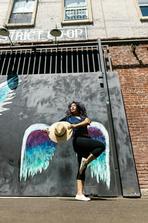 a beautiful woman standing next to a building