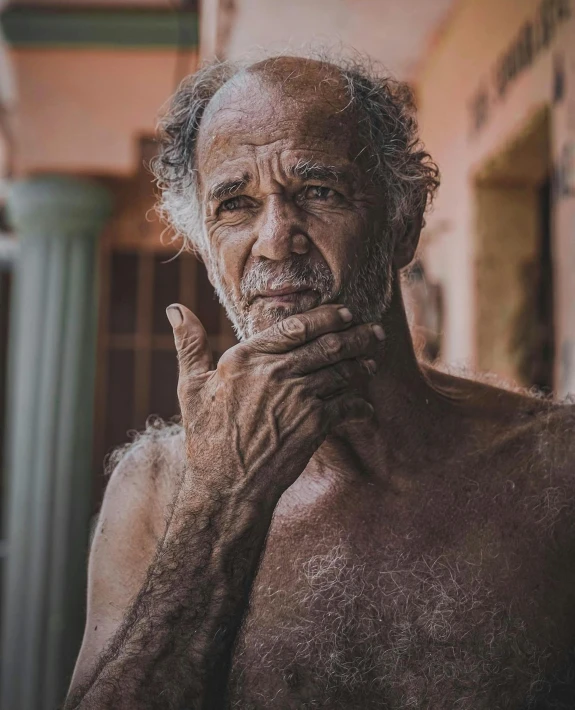 an elderly man with his hand resting on his chin