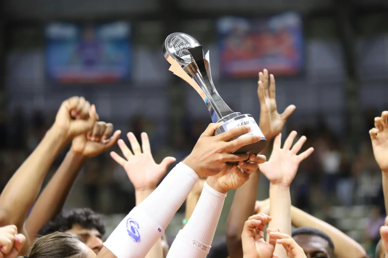 the team members hold up the trophy for the winner