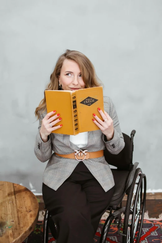a woman in a wheelchair holding up a notebook
