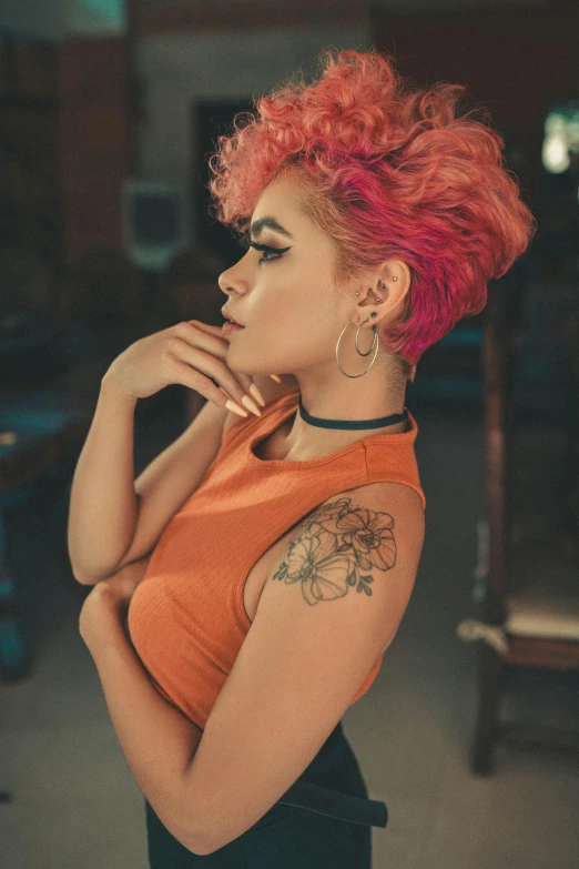 a lady with pink hair looking away from the camera