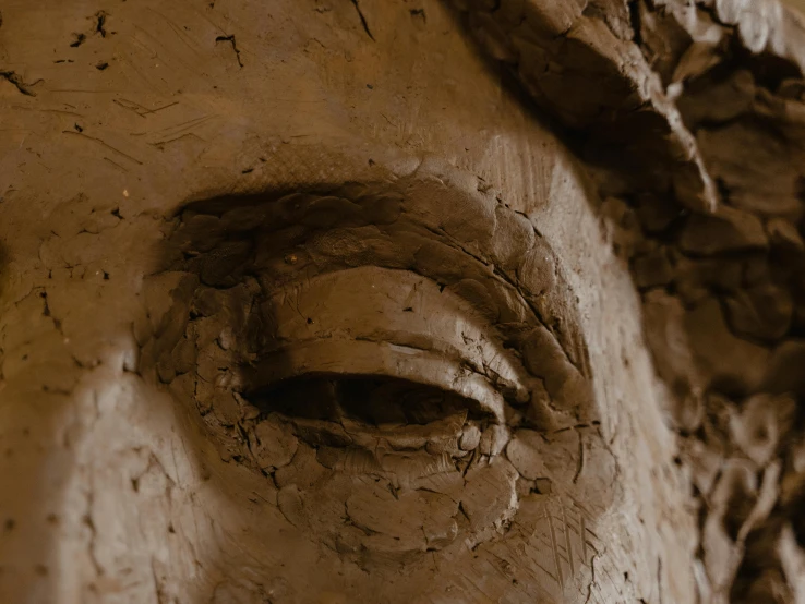 the face of an old statue in a cave