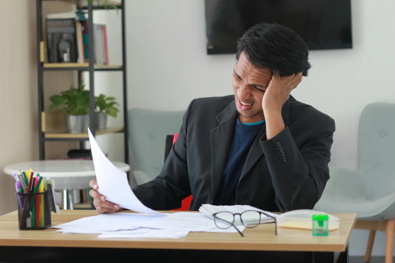 a man in glasses is sitting at a table