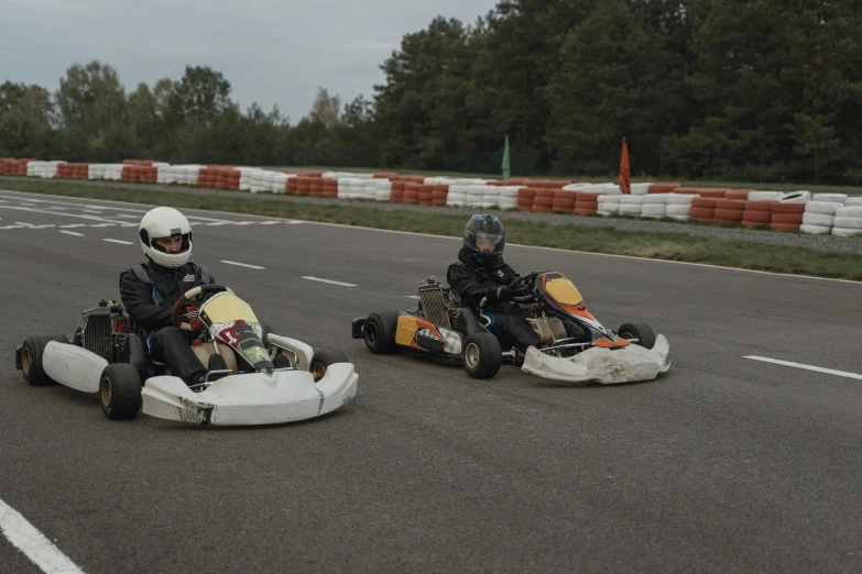 two people on kart go karts in a race track