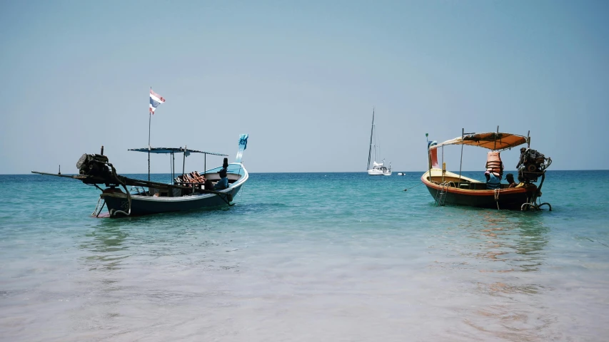 two small boats sitting next to each other on the ocean