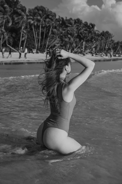 a woman sitting on the beach posing for a po