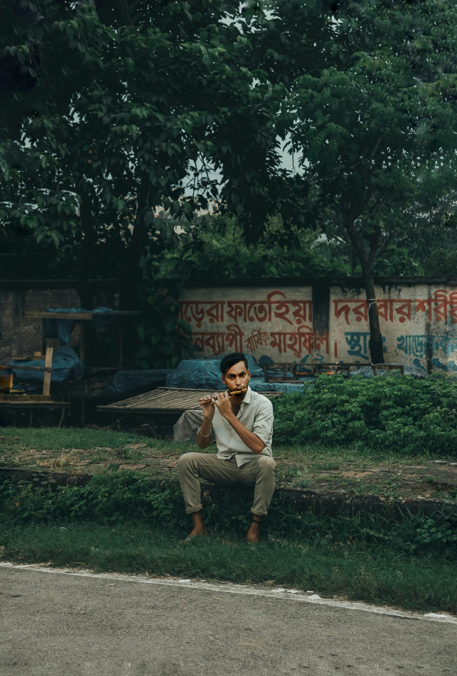 there is a man sitting on the corner of a field