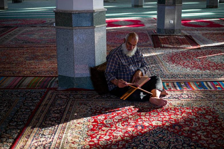 an elderly man sitting on the floor while playing croquet