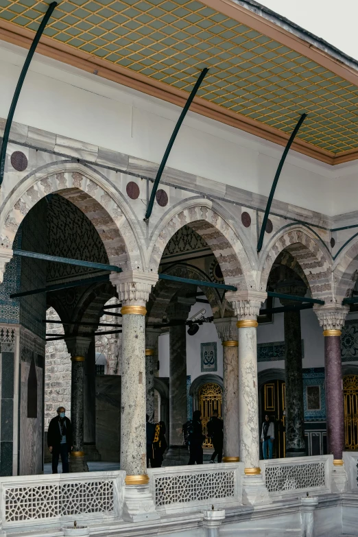 two men are standing outside of an intricate building