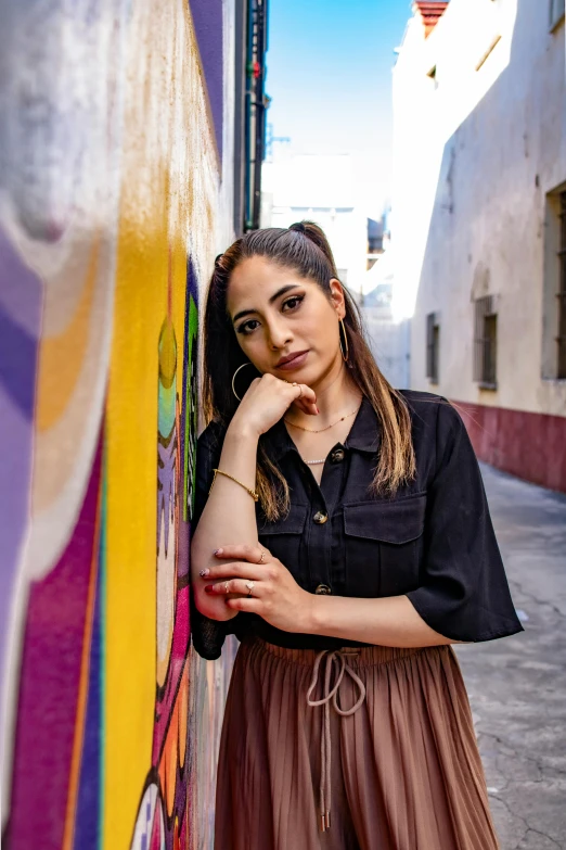 a woman leaning against the wall in front of a wall