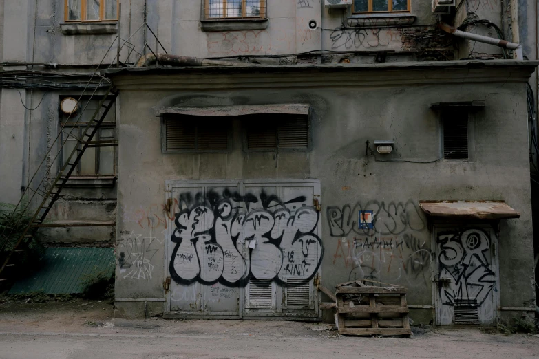 a building covered in graffiti next to a fire escape