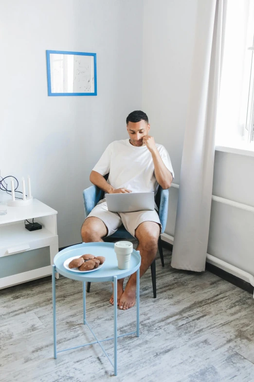 a man sits in a chair while working on his computer