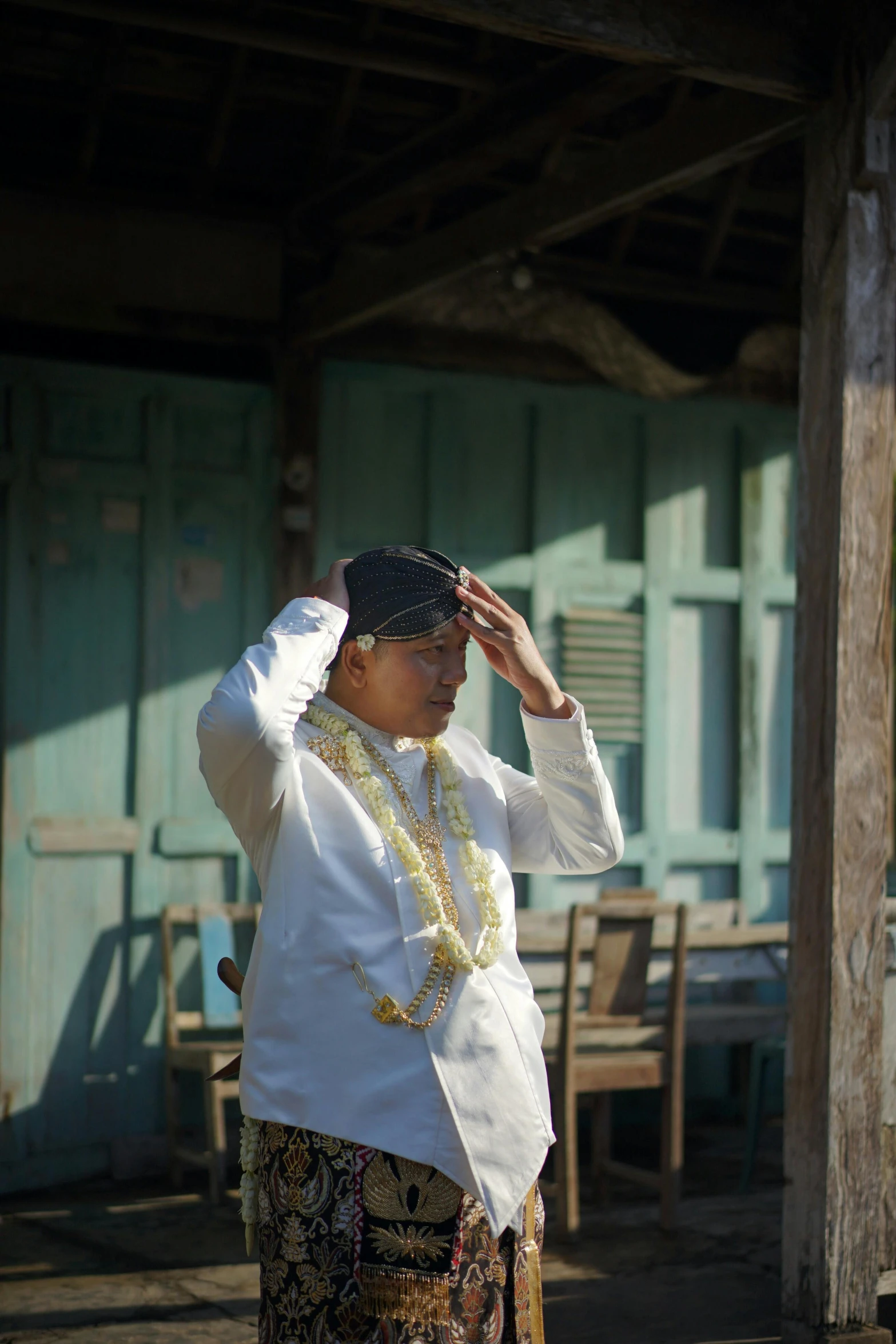 an old lady is standing in front of a building holding her hat