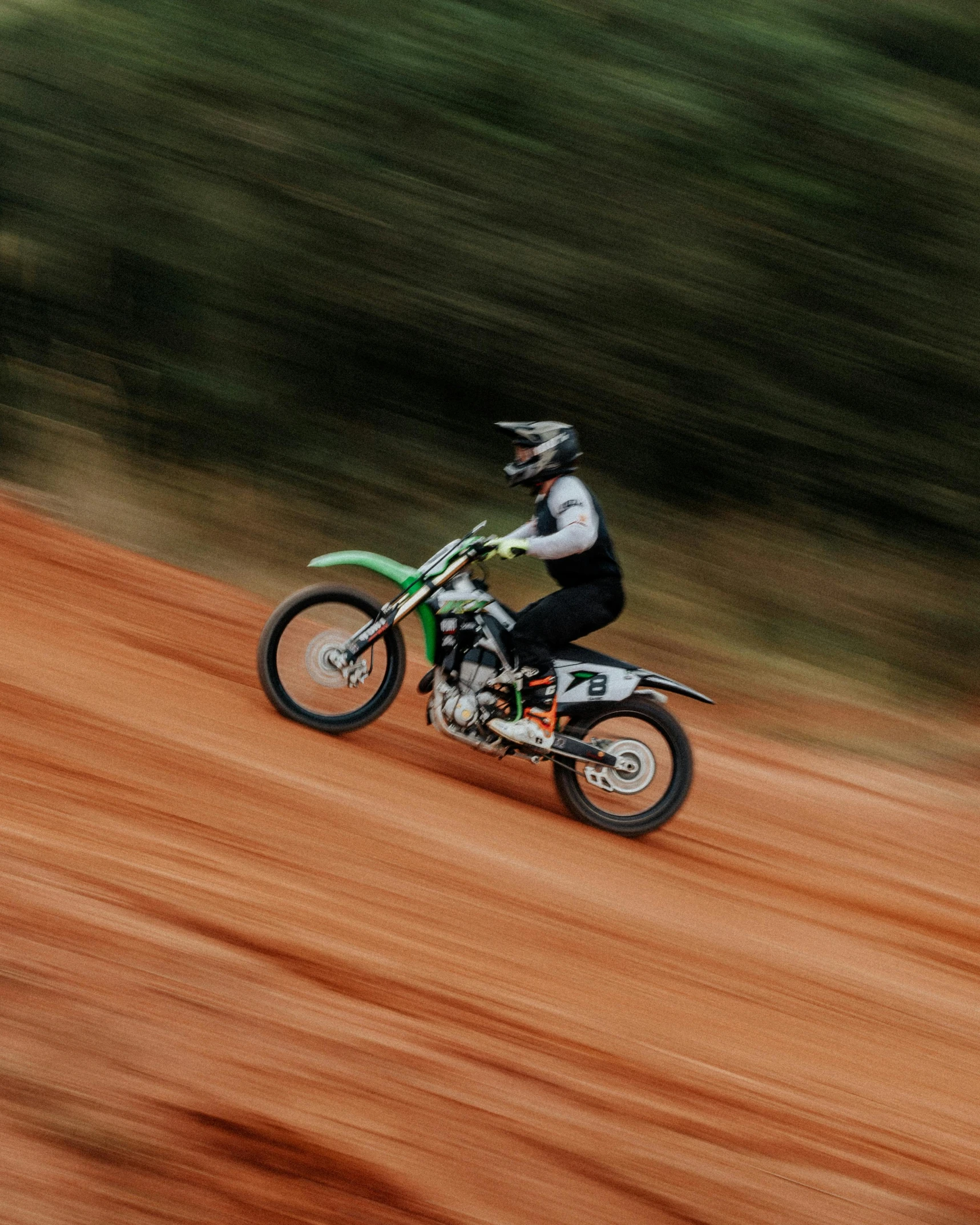 a person is riding a dirt bike on a muddy slope