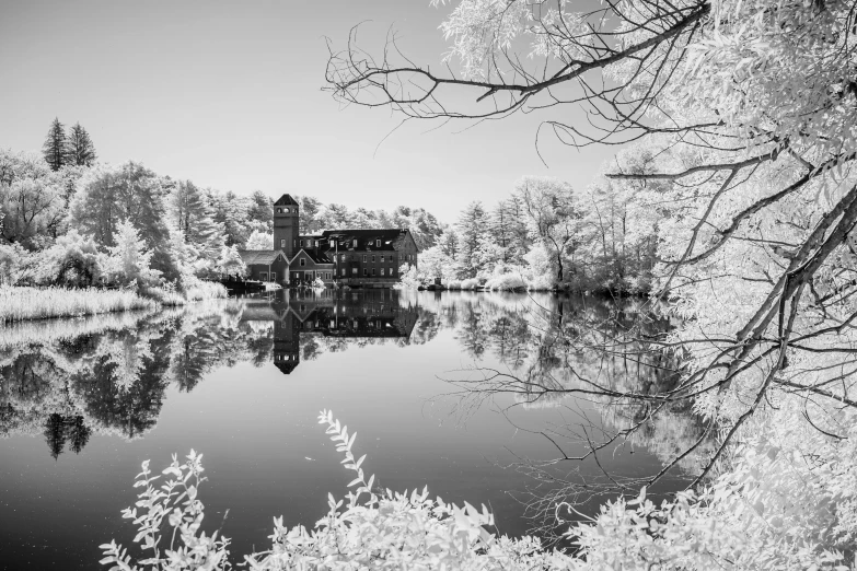 a small house sits on top of a lake in black and white