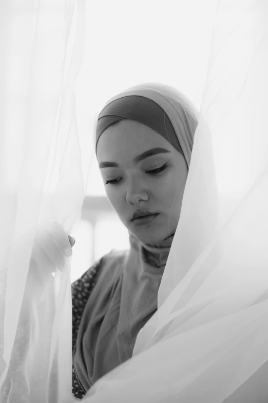 a black and white po of a woman with head scarf on