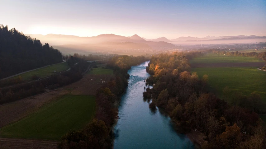 a river running between some trees in the background