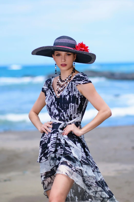 a woman in a hat walking along a beach