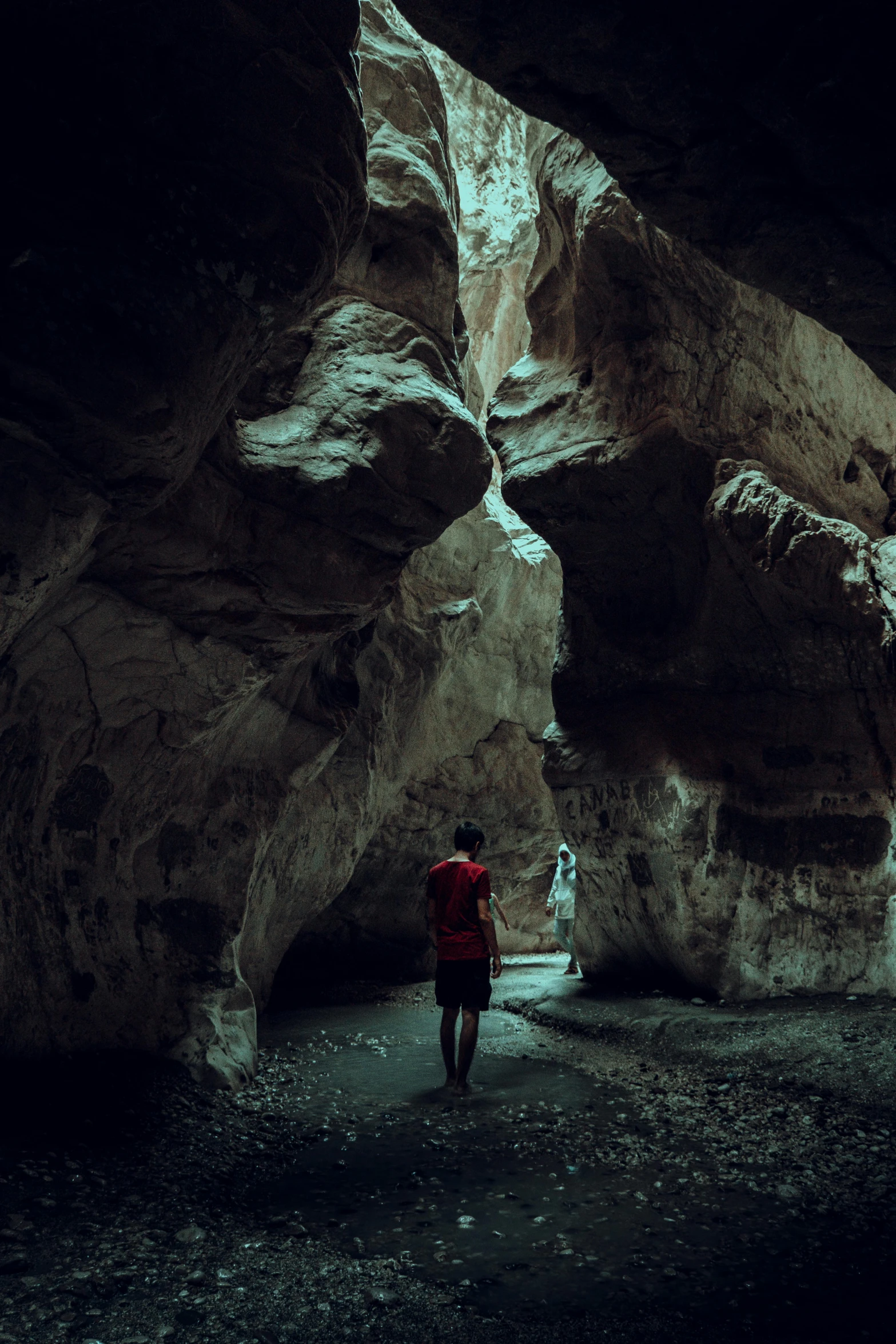 a person is walking through a cave near rocks