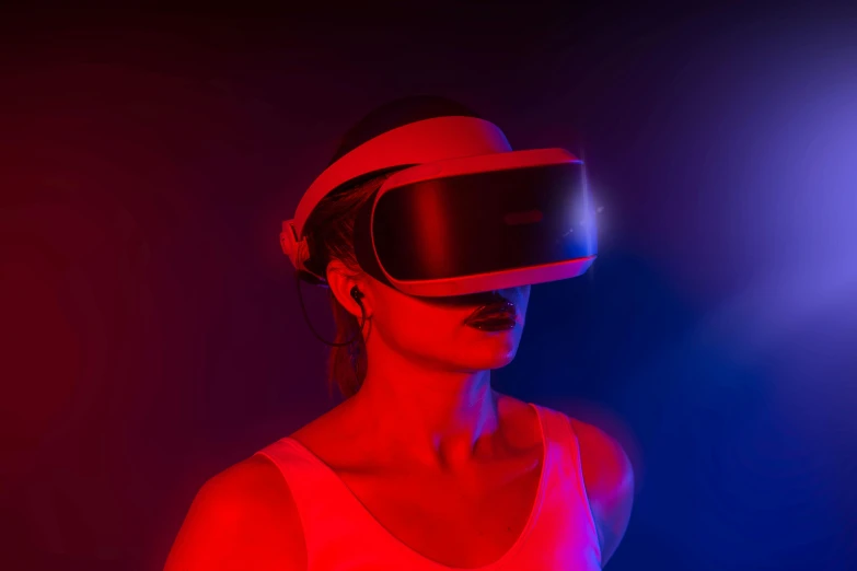 a woman standing in front of a neon colored screen with a vr goggles on her face