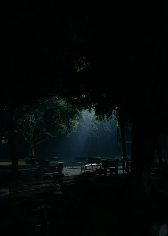 dark po of benches and tables illuminated by sunlight