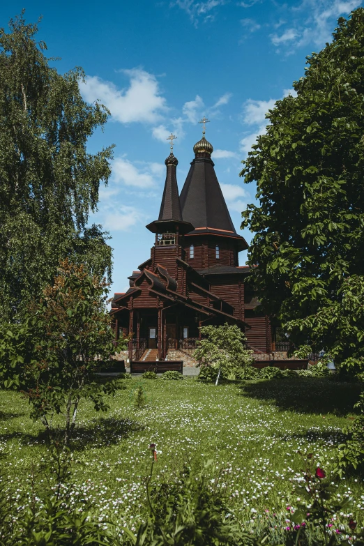 a house sitting in the middle of a forest with a tall tower