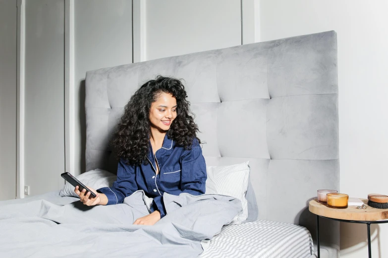 a woman sitting on top of a bed next to a wall