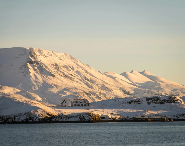 a snow covered mountain towering over a body of water