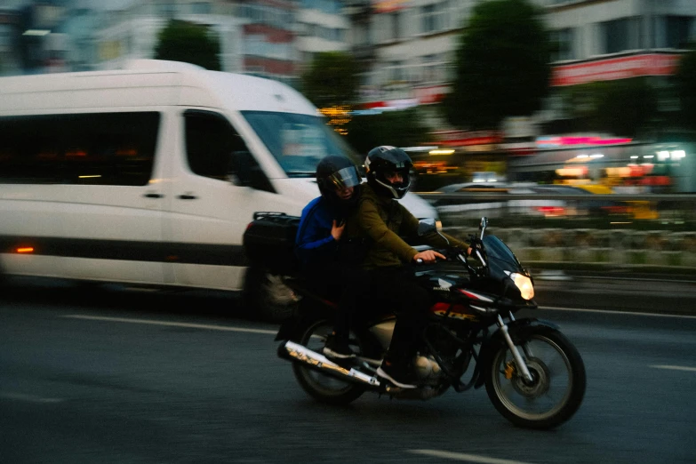 a couple riding a motorcycle on a street