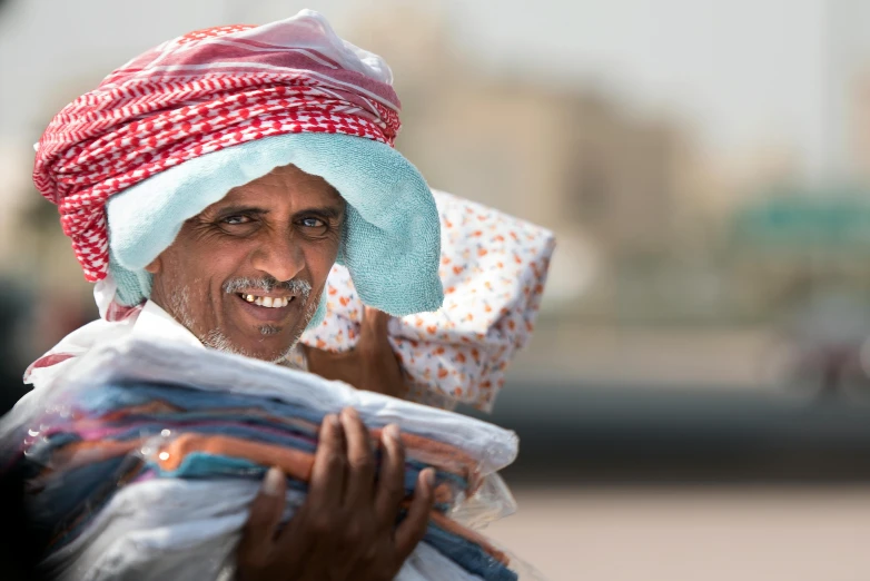 a man wearing a colorful hat is smiling at the camera