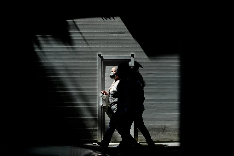 two people standing in the shadow near an open garage door