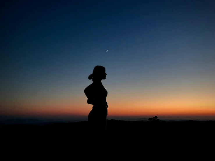 a person standing alone at sunset in the night