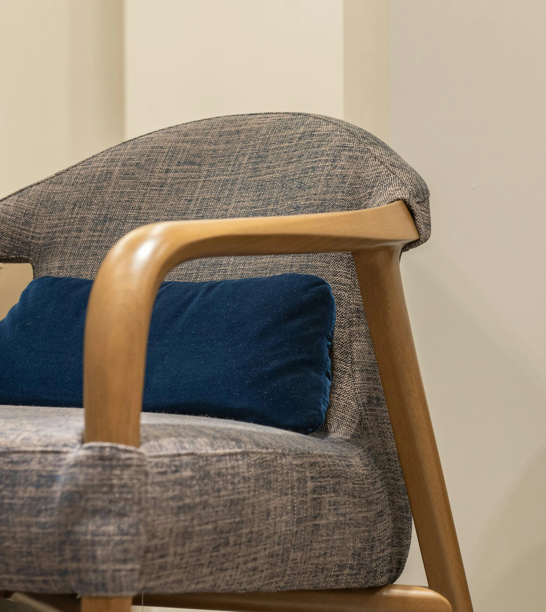 a brown wooden chair with two blue pillows