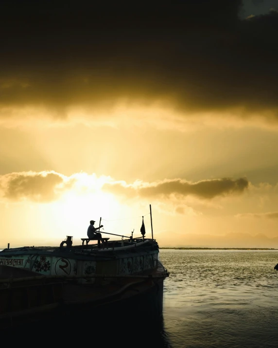 a man is fishing off the side of a boat with people on it