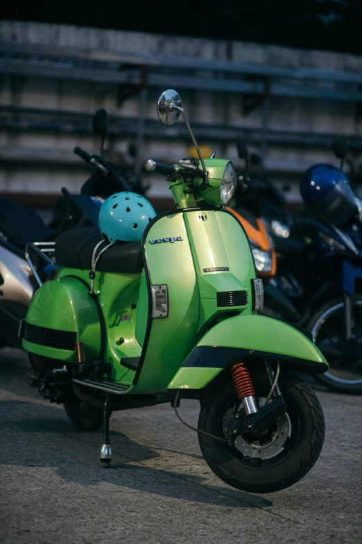 a green moped with a helmet on the back
