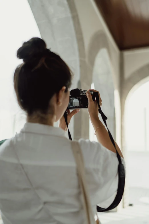 a woman is holding a camera up to take a pograph