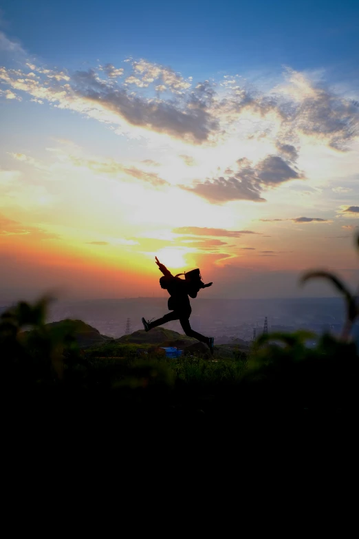 silhouette of person on sunset with raised arms and legs