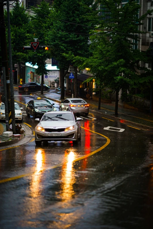 a white car stopped at an intersection during the rain