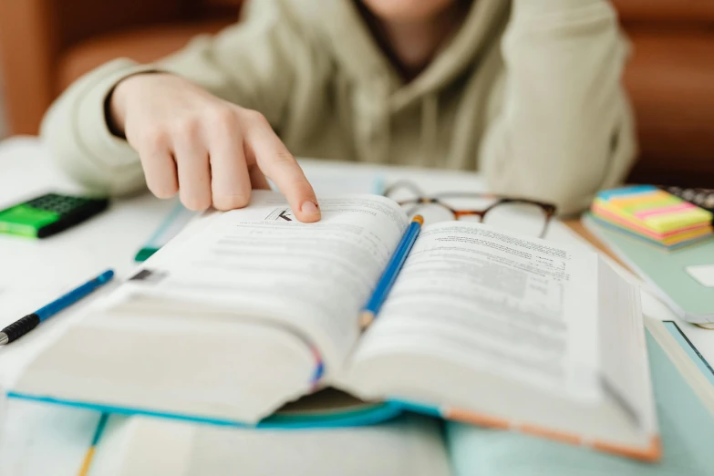 a person touching an open book on a table