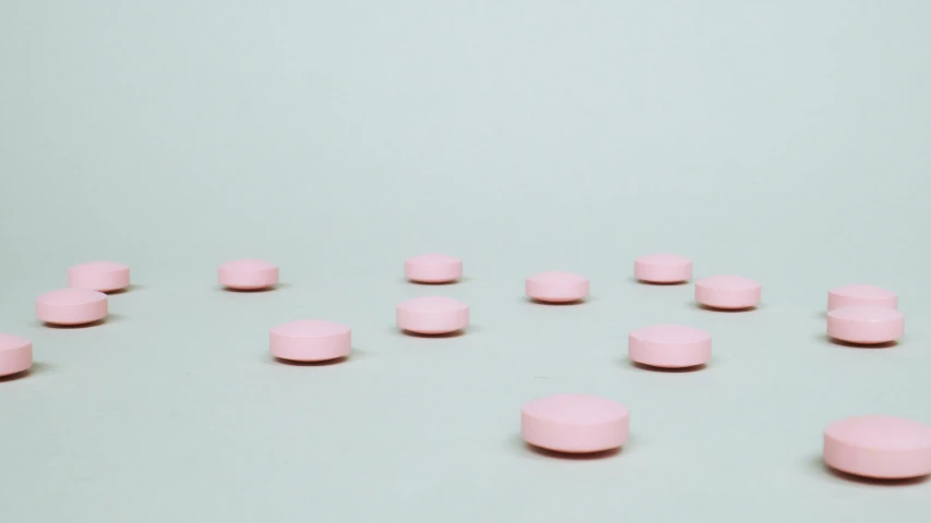 lots of pink pills lined up on the floor