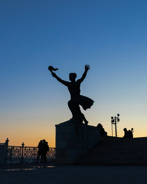 a statue of a person on top of a ledge